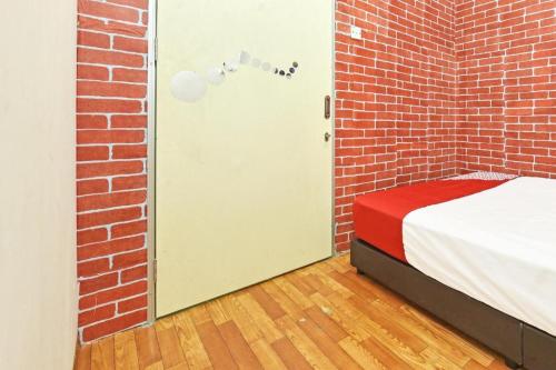 a room with a bed and a brick wall at OYO 90431 CZ Hotel in Pasir Puteh