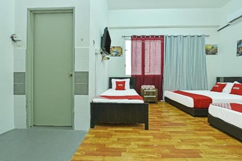 a bedroom with two beds and a sliding door at OYO 90431 CZ Hotel in Pasir Puteh