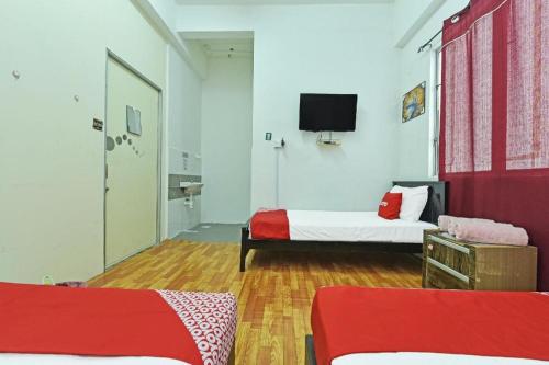 a room with two beds and a flat screen tv at OYO 90431 CZ Hotel in Pasir Puteh
