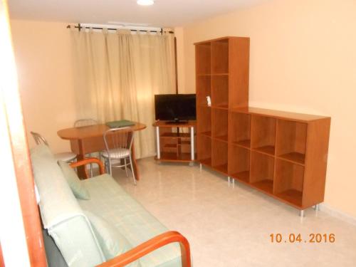 a living room with a couch and a cabinet and a table at Apartahotel Los Hermanos in Ocaña