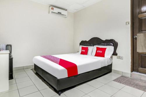 a bedroom with a large bed with red pillows at OYO 90376 Centre Point Hotel in Limbang