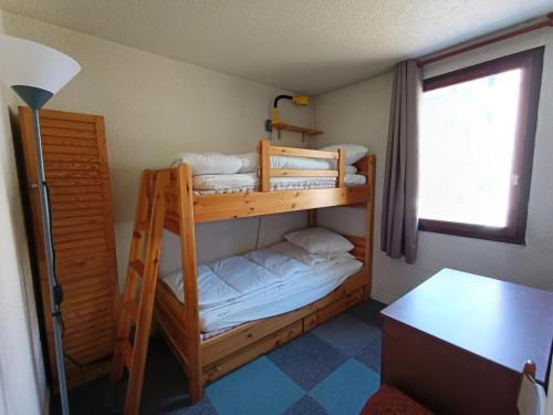 deux lits superposés dans une chambre avec un bureau dans l'établissement Résidence Praya - Appartement en front de neige - Face aux pistes MAE-8533, à Montgenèvre