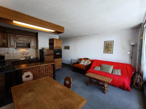 un salon avec un canapé rouge et une cuisine dans l'établissement Résidence Praya - Appartement en front de neige - Face aux pistes MAE-8533, à Montgenèvre