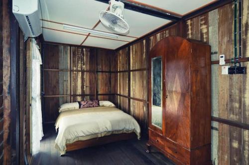 una camera da letto con un letto in una stanza con pareti in legno di OYO Home 90745 Desa Balqis Beach Resort a Malacca