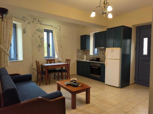 a living room with a couch and a kitchen with a table at Taletos Apartments in Stoupa