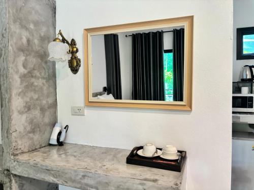 a mirror on a wall next to a counter at Lanta Buddy Resort in Ko Lanta