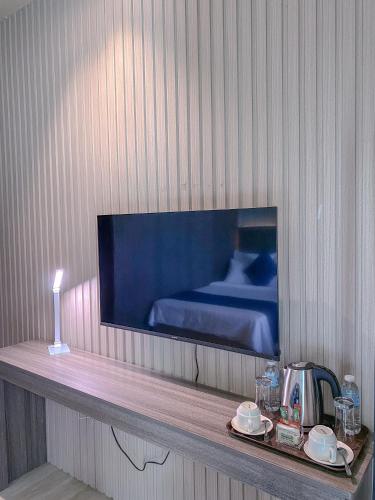 a room with a bed and a tv on a wall at The South Hideaway Oslob 
