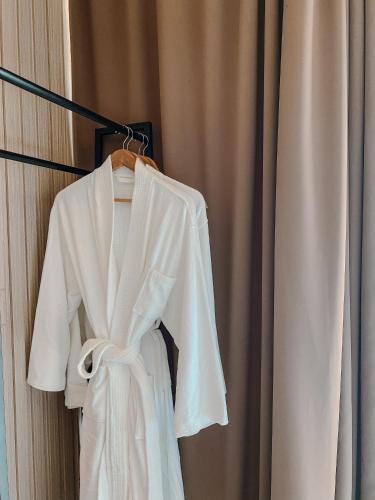 a white robe hanging on a rack next to a curtain at The South Hideaway Oslob 