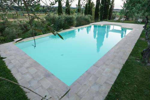 a swimming pool with blue water in a yard at Agriturismo La Ca'Solare in Palaia