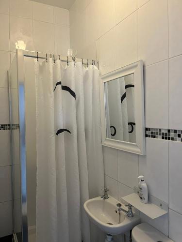 a bathroom with a shower curtain and a sink at Bourton House in Rugby