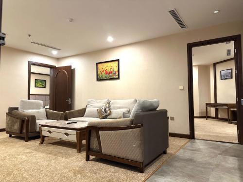 a living room with a couch and a table at Duc Huy Grand Hotel and Spa in Lao Cai