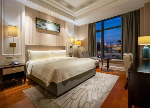 a bedroom with a bed and a large window at Wyndham Grand Xi'an Residence in Xi'an