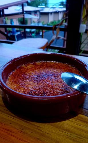 a red bowl of food on a table with a spoon at Fare Atihau Vairao in Matiti