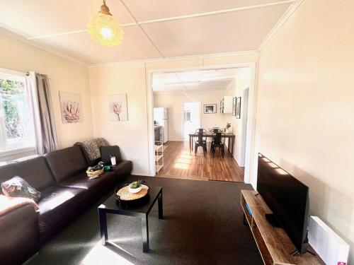 un soggiorno con un divano e un tavolo di Denham Cottage - Quart Pot Creek a Stanthorpe