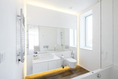 a white bathroom with a sink and a toilet at Pytloun Grand Hotel Imperial in Liberec