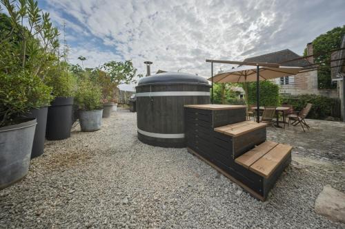 a large barrel sitting next to a table with an umbrella at Ancienne ferme renovée pour 6 en 2 logements in Fossemagne