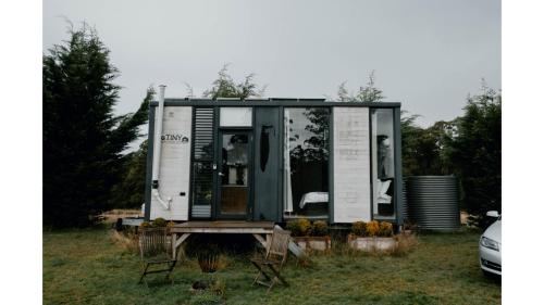 a tiny house sitting on top of a field at The Ridge by Tiny Away in Korweinguboora