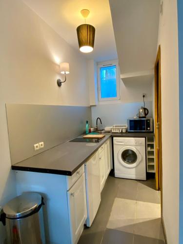 une cuisine avec un évier et une machine à laver dans l'établissement Studio proche Côte des Basques, à Biarritz