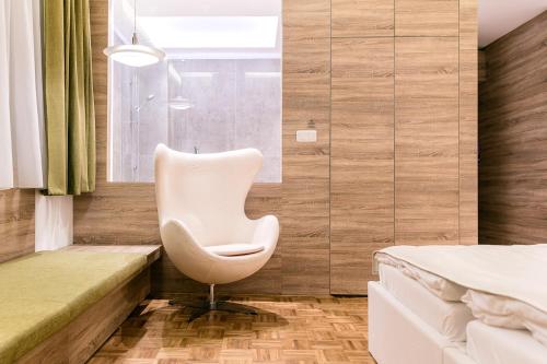 a white chair in a room with a bed at Pytloun Grand Hotel Imperial in Liberec
