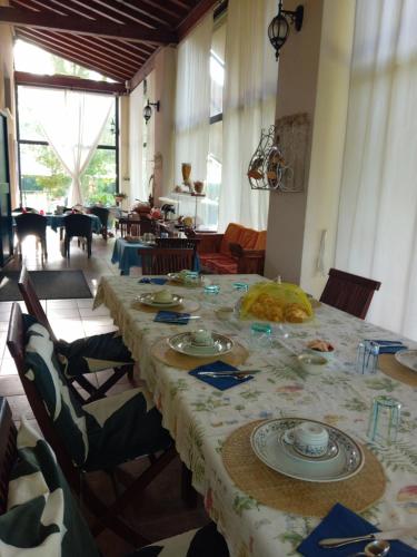 a long table with plates on it in a room at Bed & Breakfast Orizzonte in Castello di Brussa