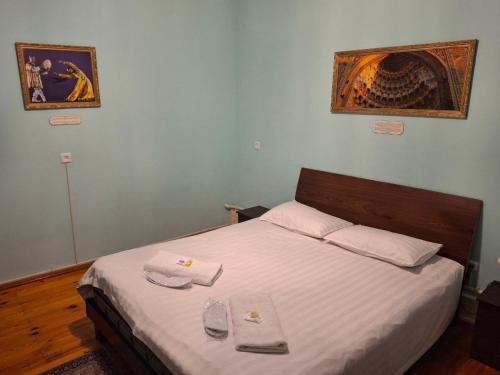 a bedroom with a bed with two towels on it at Art Hostel in Tashkent