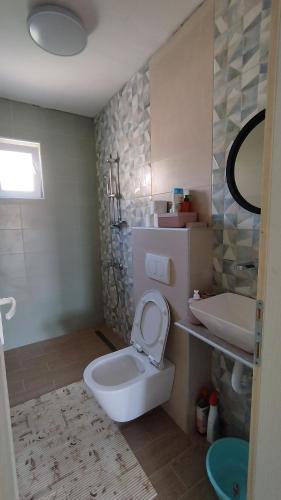 a bathroom with a white toilet and a sink at Vaske in Bar