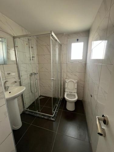 a bathroom with a shower and a toilet and a sink at Cyprus Apart Hotel in Mağusa