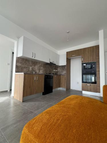 a large kitchen with wooden cabinets and an orange rug at Cyprus Apart Hotel in Mağusa