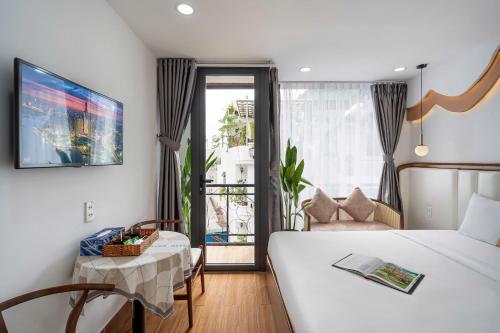 a bedroom with a bed and a table and a window at Jan Hostel in Ho Chi Minh City