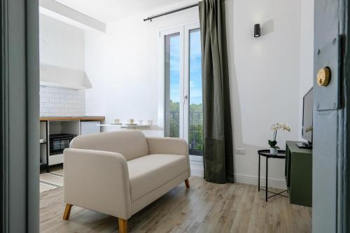 a living room with a chair and a large window at Depto in Sassari
