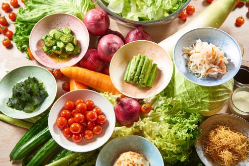 a table topped with bowls of vegetables and other ingredients at Yokohama Tokyu REI Hotel in Yokohama