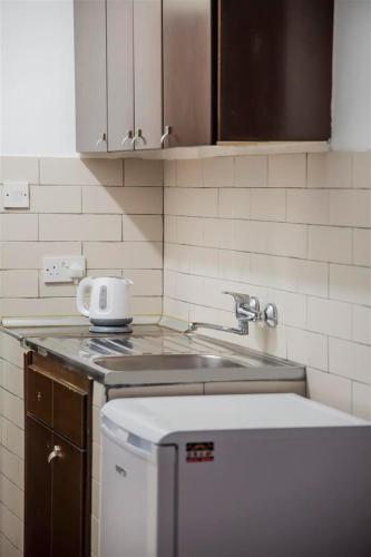 a kitchen with a sink and a counter top at Cyprus Apart Hotel in Mağusa