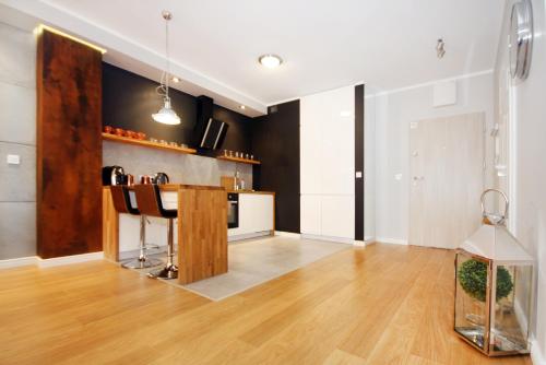 a living room with a kitchen with a counter at Livin Apartments Santocka in Szczecin