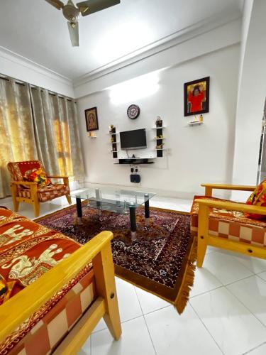a living room with a bed and a tv at Serenity by Limitless Stays in Puttaparthi