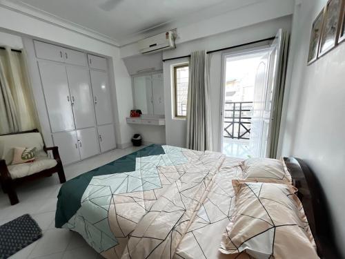 a bedroom with a bed and a large window at Serenity by Limitless Stays in Puttaparthi