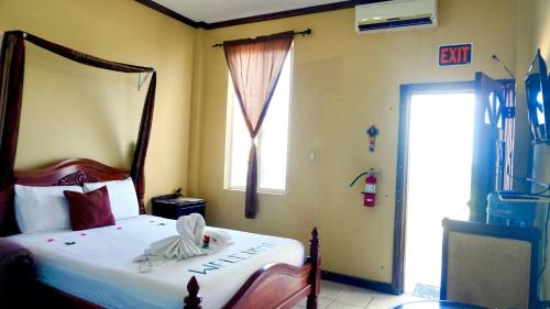 伯利兹城See Belize TRANQUIL SeaView Studio with Balcony, Pool, Deck Kitchenette 2nd FL的带床和窗户的卧室