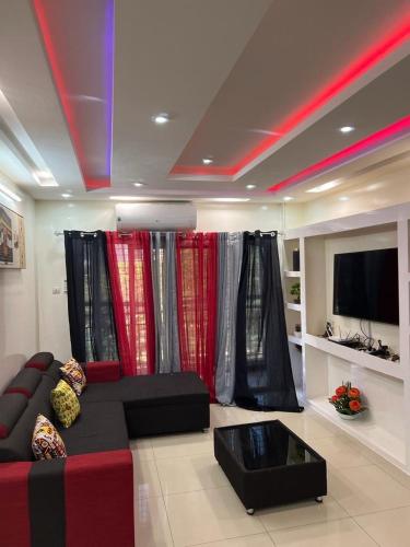 a living room with a couch and a tv at Mo Residence SD City in Dakar