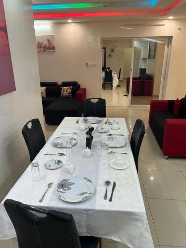 a dining table with a white tablecloth and black chairs at Mo Residence SD City in Dakar