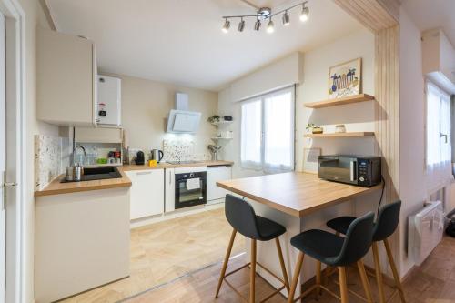 eine Küche mit einem Holztisch und zwei Stühlen in der Unterkunft Very nice apartment in Mulhouse Lambert city center in Mulhouse