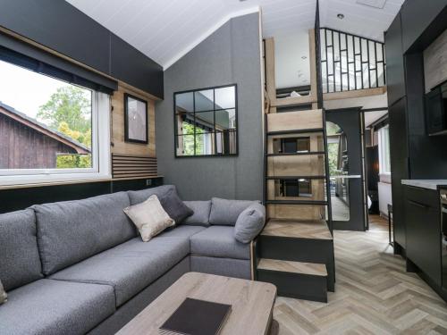 a living room with a couch and a book shelf at Lingy Luxury Family Pod in Keswick