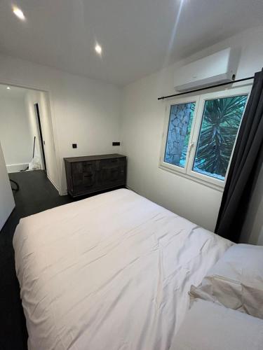 une chambre avec un grand lit blanc et une fenêtre dans l'établissement Provençal and modern house, à Grasse