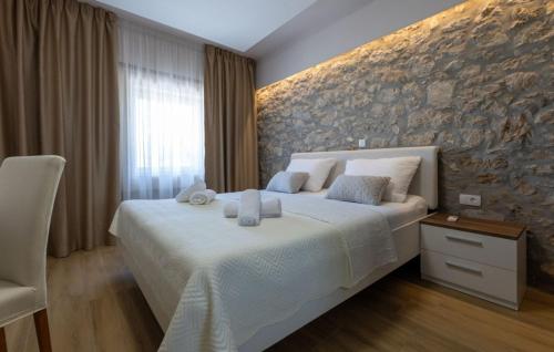 una camera da letto con un letto e un muro di pietra di House Vidovic by Villas Guide a Mlinište