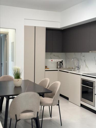 a kitchen with a dining room table and chairs at ΘΕΑ 5 Comfortable 1BR and 2BR Apartments in Mor Menekshe