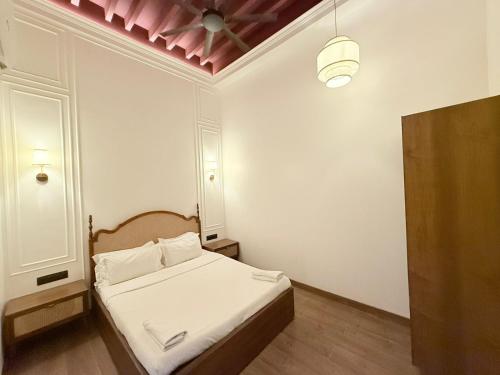 a small bedroom with a bed with white sheets at Gulf Hotel Mumbai- The Boutique Hotel Colaba Mumbai in Mumbai
