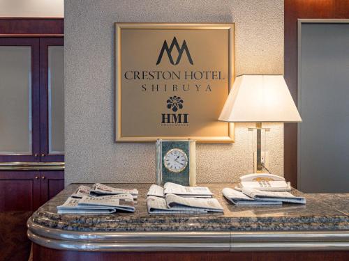 a table with a clock and a lamp on it at Shibuya Creston Hotel in Tokyo
