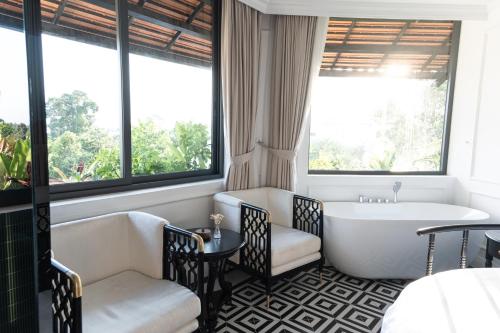 a bathroom with a tub and a bath tub at The City Boutique Hotel in Bien Hoa