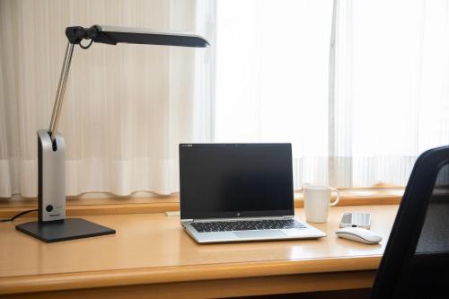 a laptop computer sitting on a desk with a lamp at En Hotel Akita エンホテル秋田 in Akita