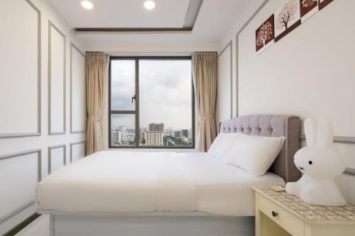 een witte slaapkamer met een bed en een raam bij Dear You, Apartment! Saigon - Rivergate Building in Ho Chi Minh-stad