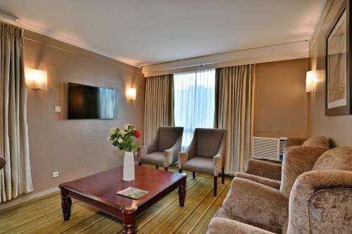 a living room with a couch and chairs and a table at Holiday Inn - Harare by IHG in Harare