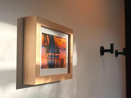 a framed picture of a sailboat on a wall at Chez PASCAL et KIM in Papetoai